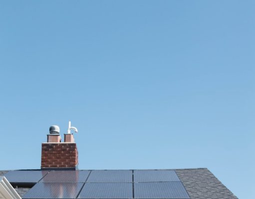 brown brick house with solar panels on roof