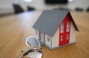 white and red wooden house miniature on brown table